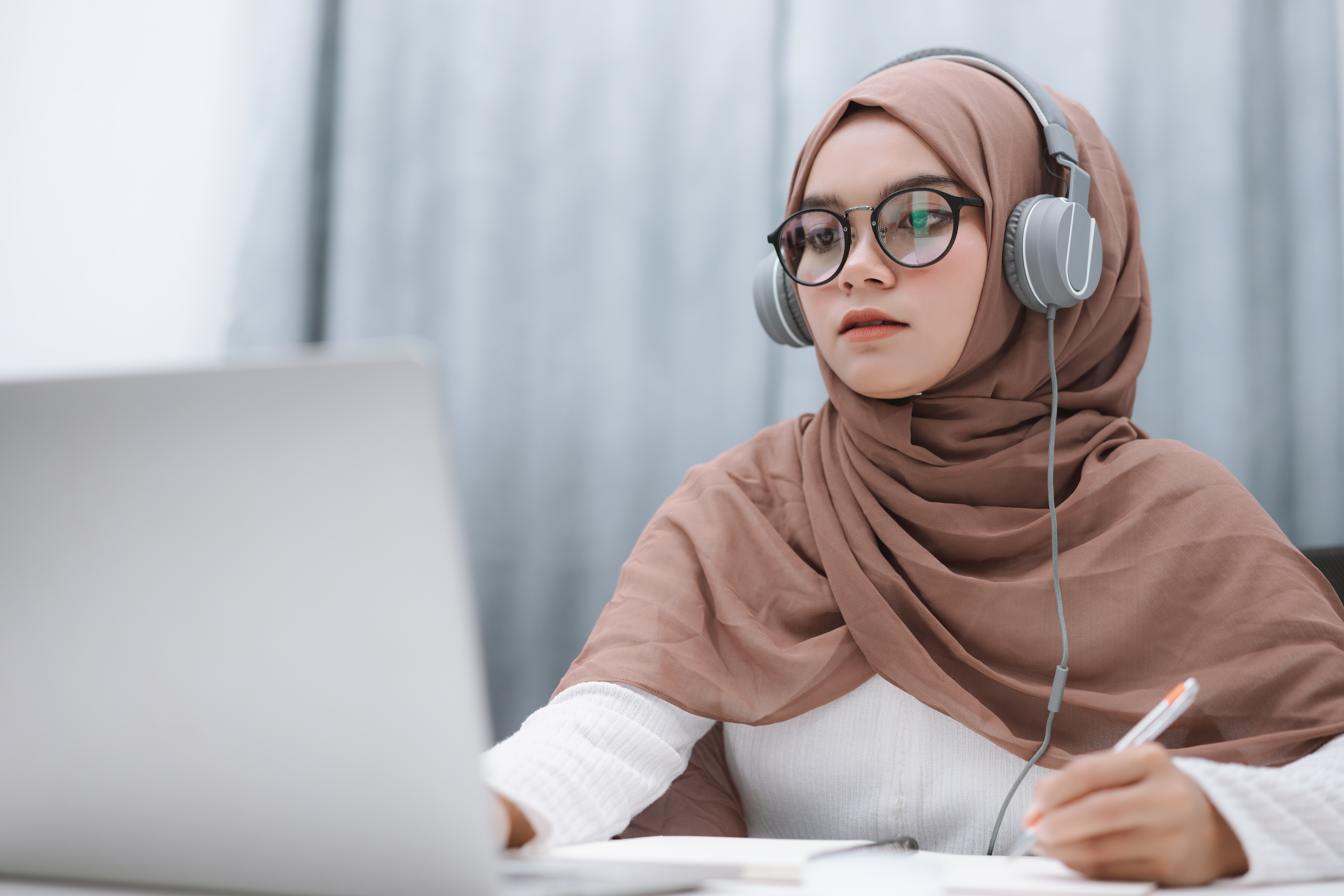 Student wearing nheadphones using a laptop